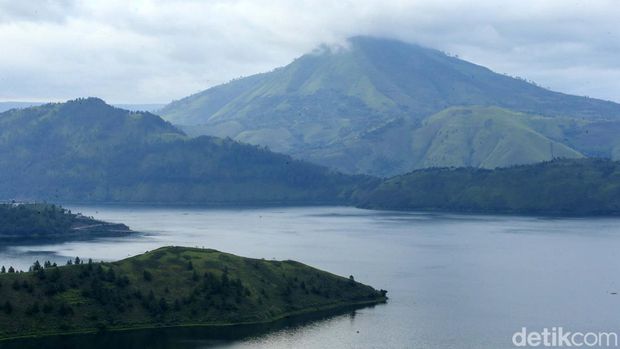 Pengunjung berfoto di Bukit Holbung, Samosir, Sumatera Utara, Rabu (15/2/2023). Keindahan bukit ini dapat dinikmati wisatawan hanya dengan menaiki anak tangga.
