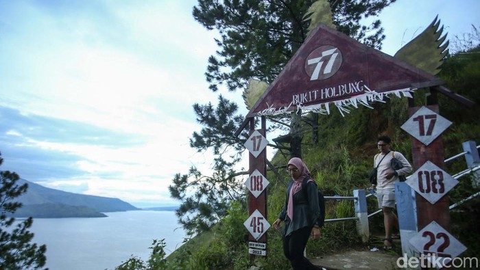 Menikmati Keindahan Danau Toba Dari Bukit Holbung Pengunjung berfoto di Bukit Holbung, Samosir, Sumatera Utara, Rabu (15/2/2023). Keindahan bukit ini dapat dinikmati wisatawan hanya dengan menaiki anak tangga.
