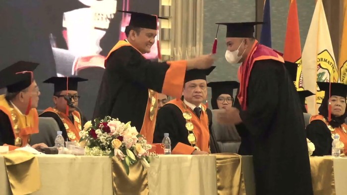 Momen seremoni pemindahan kuncir toga Rojali mahasiswa IBI Kosgoro 1957 yang kehilangan ayahnya sesaat sebelum berangkat ke acara wisuda