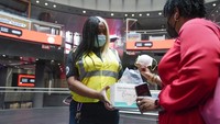 Karyawan MTA Shanita Hancle (kiri), membagikan masker kepada penumpang di pintu masuk stasiun kereta bawah tanah di New York, Kamis (8/6/2023). Polusi udara dari kebakaran hutan Kanada masih menyelimuti AS bagian timur laut.