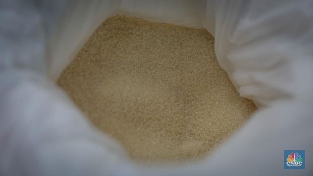 Pedagang menimbang dan mengemas gula pasir di Pasar Rumput, Jakarta, Jumat (9/6/2023). Harga gula pasir di Pasar Rumput rata-rata dijual dengan harga Rp15 ribu per kilogram. (CNBC Indonesia/Faisal Rahman)
