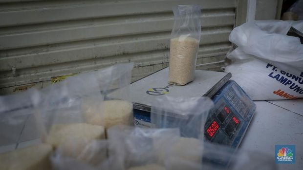 Pedagang menimbang dan mengemas gula pasir di Pasar Rumput, Jakarta, Jumat (9/6/2023). Harga gula pasir di Pasar Rumput rata-rata dijual dengan harga Rp15 ribu per kilogram. (CNBC Indonesia/Faisal Rahman)
