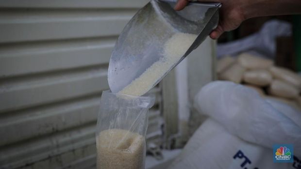 Pedagang menimbang dan mengemas gula pasir di Pasar Rumput, Jakarta, Jumat (9/6/2023). Harga gula pasir di Pasar Rumput rata-rata dijual dengan harga Rp15 ribu per kilogram. (CNBC Indonesia/Faisal Rahman)