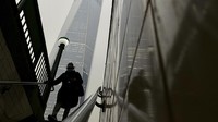Seorang komuter masuk ke kereta bawah tanah saat asap dari kebakaran hutan di Kanada menutupi sebagian One World Trade Center di Manhattan. AP/Daniel Derella  