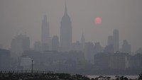 Matahari terbit di atas cakrawala Kota New York yang berkabut terlihat dari Jersey City, NJ, Rabu (7/6/2023). AP/Seth Wenig  