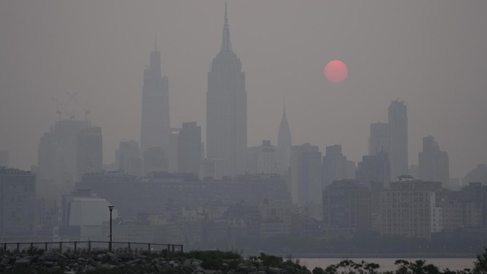 Penampakan Kabut Asap Kebakaran Selimuti Ikon-ikon Amerika Serikat The sun rises over a hazy New York City skyline as seen from Jersey City, N.J., Wednesday, June 7, 2023. (AP Photo/Seth Wenig)