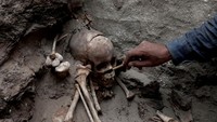 Seorang arkeolog memeriksa tulang kuno yang ditemukan di makam pra-Inca di Lembah Huaral di Lima, Peru pada 31 Mei 2023. 
