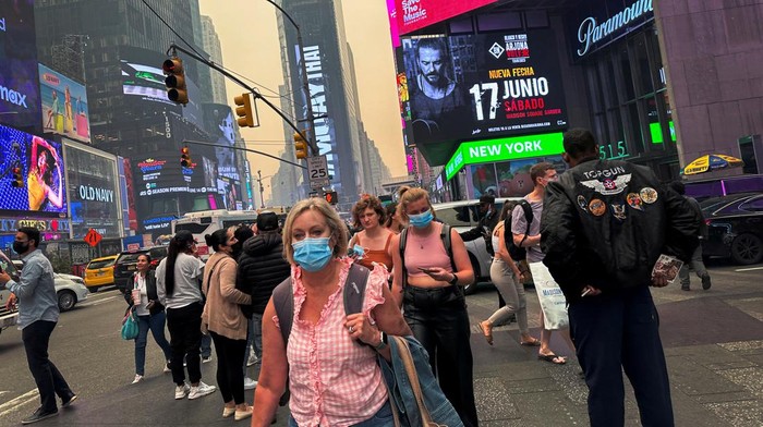 People crowd in Times Square as Manhattan is shrouded in haze and smoke which drifted south from wildfires in Canada, in New York City, New York, U.S., June 7, 2023. REUTERS/Maye-E Wong
