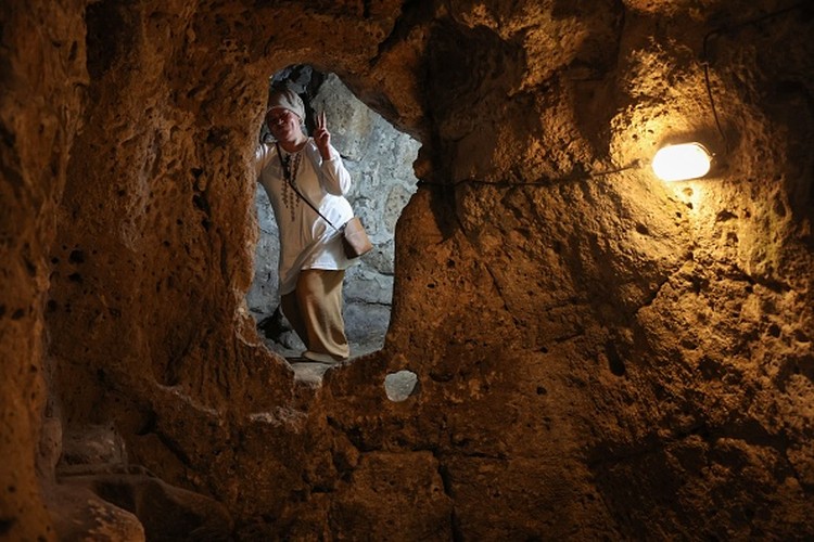 A tourist walks through a passage in the Derinkuyu underground city, in Turkeys central Nevsehir province, on August 24, 2022. - The ancient city of Elengubu, known today as Derinkuyu, reaches the depth of 85m below the Earths surface, and could accommodate up to 20,000 people. (Photo by OMAR HAJ KADOUR / AFP) (Photo by OMAR HAJ KADOUR/AFP via Getty Images)