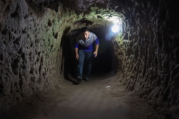 1242703631 A tourist walks through a passage in the Derinkuyu underground city, in Turkeys central Nevsehir province, on August 24, 2022. - The ancient city of Elengubu, known today as Derinkuyu, reaches the depth of 85m below the Earths surface, and could accommodate up to 20,000 people. (Photo by OMAR HAJ KADOUR / AFP) (Photo by OMAR HAJ KADOUR/AFP via Getty Images)