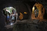 A tourist walks through a passage in the Derinkuyu underground city, in Turkeys central Nevsehir province, on August 24, 2022. - The ancient city of Elengubu, known today as Derinkuyu, reaches the depth of 85m below the Earths surface, and could accommodate up to 20,000 people. (Photo by OMAR HAJ KADOUR / AFP) (Photo by OMAR HAJ KADOUR/AFP via Getty Images)