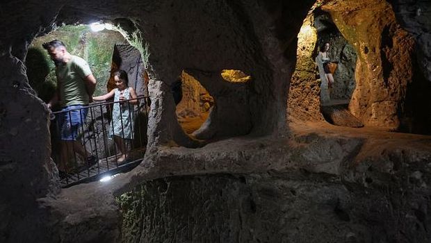 A tourist walks through a passage in the Derinkuyu underground city, in Turkey's central Nevsehir province, on August 24, 2022. - The ancient city of Elengubu, known today as Derinkuyu, reaches the depth of 85m below the Earth's surface, and could accommodate up to 20,000 people. (Photo by OMAR HAJ KADOUR / AFP) (Photo by OMAR HAJ KADOUR/AFP via Getty Images)
