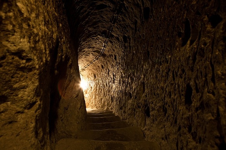 1242703631 A tourist walks through a passage in the Derinkuyu underground city, in Turkeys central Nevsehir province, on August 24, 2022. - The ancient city of Elengubu, known today as Derinkuyu, reaches the depth of 85m below the Earths surface, and could accommodate up to 20,000 people. (Photo by OMAR HAJ KADOUR / AFP) (Photo by OMAR HAJ KADOUR/AFP via Getty Images)