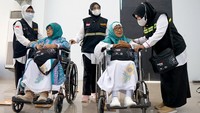 Petugas berbincang dengan jamaah calon haji lanjut usia. 