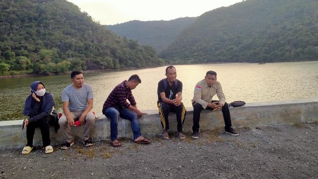 Pengunjung sedang menikmati pemandangan di Embung Mumbu.