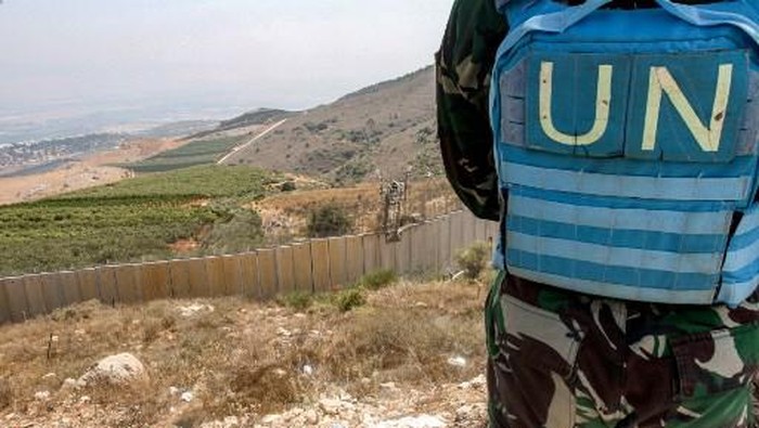 A peacekeeper part of the United Nations Interim Force in Lebanon (UNIFIL) stands at a position on the outskirts of the southern Lebanese border village of Adaisseh, opposite the border with Israel, on August 30, 2022. (Photo by Mahmoud ZAYYAT / AFP)