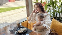 Habiskan waktu berkualitas bersama anak keduanya, Tasya ditemani kopi dan camilan. Tampak pemandangan pantai dan langit biru cerah di belakangnya. Foto: Instagram tasyafarasya