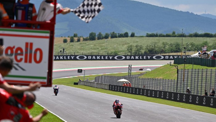 Ducati Italian rider Francesco Bagnaia crosses the finish line to win the race as a checkered flag is waved during the Italian MotoGP race at Mugello Circuit in Mugello, on June 11, 2023. (Photo by Filippo MONTEFORTE / AFP) (Photo by FILIPPO MONTEFORTE/AFP via Getty Images)