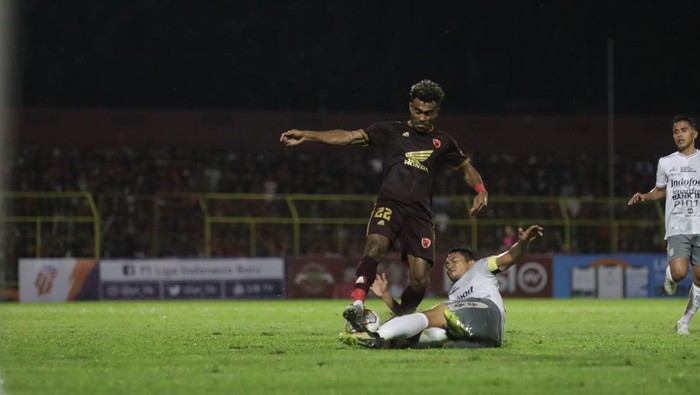 Pemain PSM Makassar Yance Sayuri mendapat hadangan dari pemain Bali United.