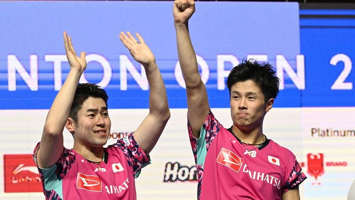 Takuro Hoki (R) and Yugo Kobayashi (L) of Japan react on the podium after defeating Liang Weikeng and Wang Chang of China in their mens doubles final match at the Singapore Open badminton tournament in Singapore on June 11, 2023. (Photo by Roslan RAHMAN / AFP) (Photo by ROSLAN RAHMAN/AFP via Getty Images)