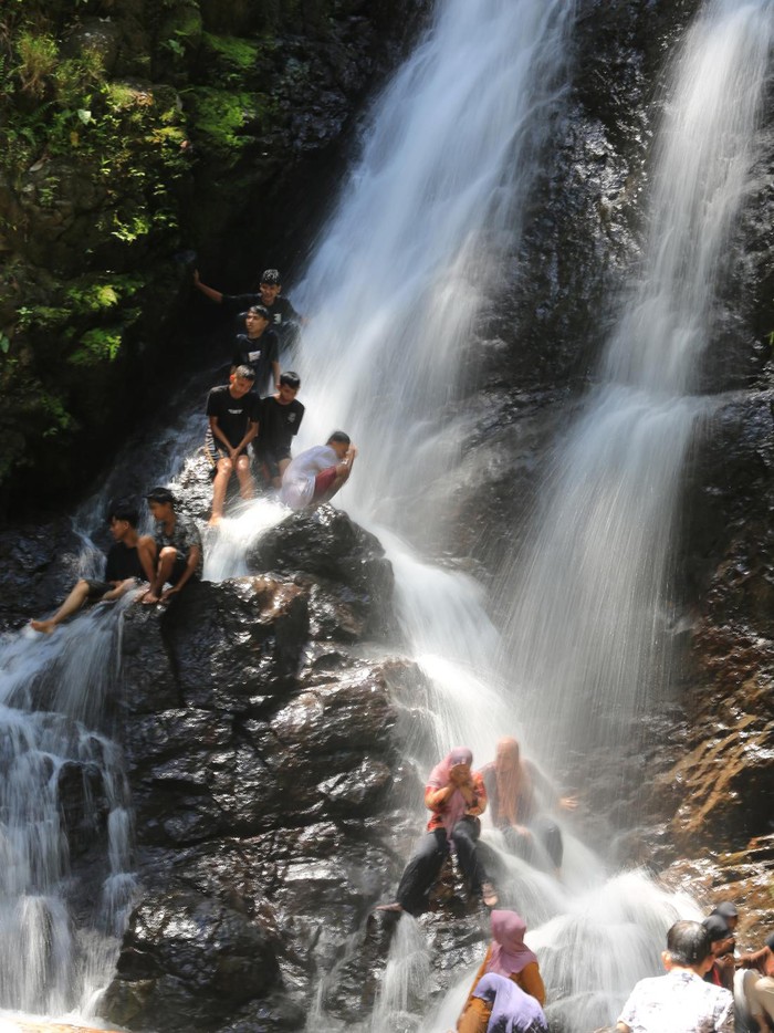 Sejumlah pengunjung berada di kawasan objek wisata air terjun alue minyek sapi Desa Sarah Raya, Kecamatan Pasie Raya, Aceh Jaya, Aceh, Minggu (11/6/2023). Obyek wisata alam yang baru dibuka untuk umum sekitar dua bulan lalu tersebut berada sekitar 30 kilometer dari jalan lintas nasional, selain menawarkan keindahan panorama air terjun juga dikelilingi pemandangan alam yang asri yang ramai dikunjungi wisatawan lokal untuk menghabiskan waktu libur akhir pekan bersama keluarganya. ANTARA FOTO/Syifa Yulinnas/nz.