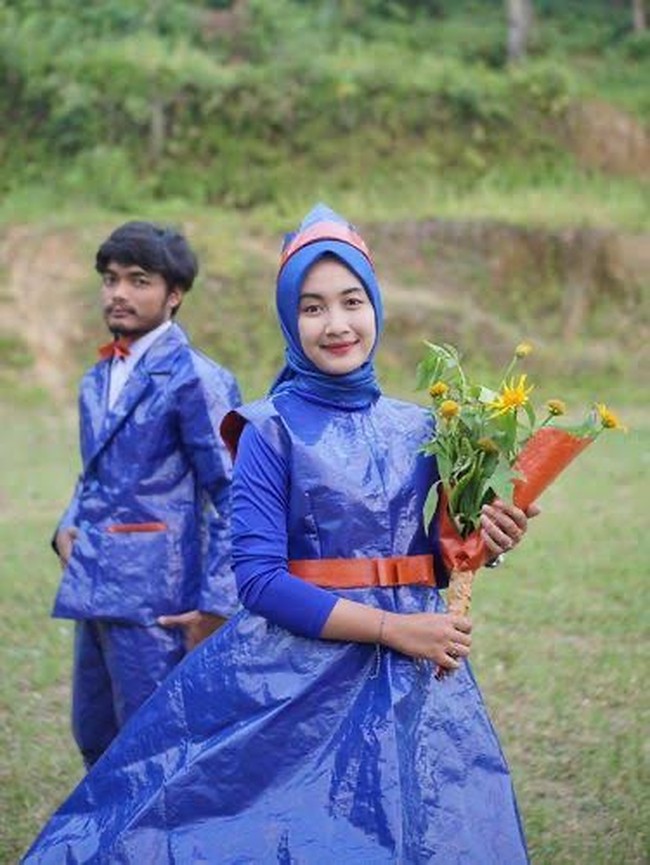 Pasangan ini menyulap kain terpal menjadi setelan jas dan gaun yang dilengkapi dengan belt dan mahkota untuk sang wanita. Kreatif bukan? Foto: Dok. Twitter, Instagram