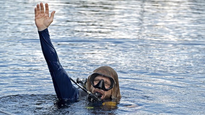 In this photo provided by the Florida Keys News Bureau, diving explorer and medical researcher Dr. Joseph Dituri, left, basks in the sun Friday, June 9, 2023, after completing a 100-day underwater mission in the Jules Undersea Lodge marine habitat at the bottom of a lagoon in Key Largo, Fla. Dituri broke the previous 73-day record for underwater human habitation at ambient pressure, undertook medical and marine science research and interacted online with more than 5,500 students during his Project Neptune 100 mission organized by the Marine Resources Development Foundation. (Andy Newman/Florida Keys News Bureau via AP)