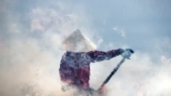 Foto berjudul Into the Cloud ini dipotret menembus asap dan kilauan panas, seorang wanita yang mengipasi asap di ladangnya di Hoi An, Vietnam tampaknya muncul dari balik awan. Foto: Réhahn via 121cliks