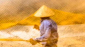 Mosaik cahaya keemasan mengelilingi nelayan ini seperti sarang lebah. Dibidik melalui jaring jaring ikan kuning, gambar terendam dalam warna seperti glasir. Foto: Réhahn via 121cliks