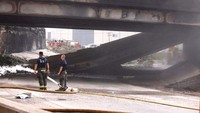 Petugas pemadam kebakaran melihat bagian Interstate 95 yang runtuh, yang disebabkan oleh kebakaran kendaraan besar, di Philadelphia, Pennsylvania, pada 11 Juni 2023.  
