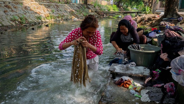 Menghemat Air Bersih, Warga Tangerang Pilih Cuci Baju di Sungai In a bid to conserve clean water, a number of residents in Tangerang, Indonesia, were forced to utilize contaminated river water for washing their clothes on June 11, 2023. This measure was taken as an effort to minimize the consumption of clean water, which would otherwise require them to purchase two jerry cans at the cost of IDR7,000 for their daily needs, such as cooking and bathing. (Photo by Kevin Herbian/NurPhoto via Getty Images)
