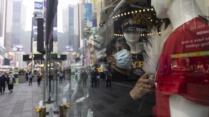 A worker wearing a protective mask adjusts a window display due to poor air quality from wildfires in Canada in Times Square in New York, US, on Thursday, June 8, 2023. The US Northeast will continue to breathe in choking smoke from fires across eastern Canada for the next few days, raising health alarms across impacted areas. Photographer: Angus Mordant/Bloomberg via Getty Images