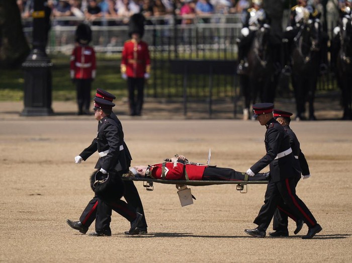 Sejumlah Prajurit Inggris Pingsan Saat Parade Militer An officer of the Welsh Guards faints in hot weather during the Colonel's Review, the final rehearsal of the Trooping the Colour, the King's annual birthday parade, at Horse Guards Parade in London, Saturday, June 10, 2023. (AP Photo/Alberto Pezzali)