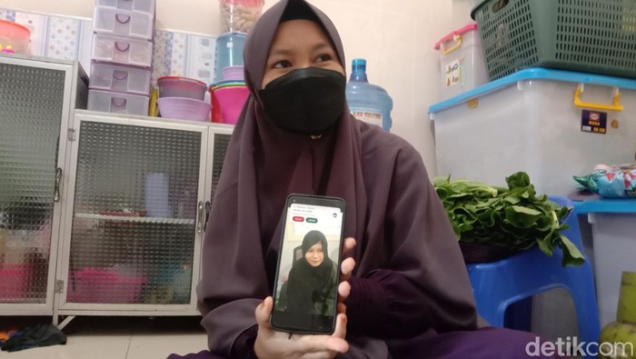 Sri Wasriah menunjukkan foto kakaknya yang jadi TKW di Arab Saudi