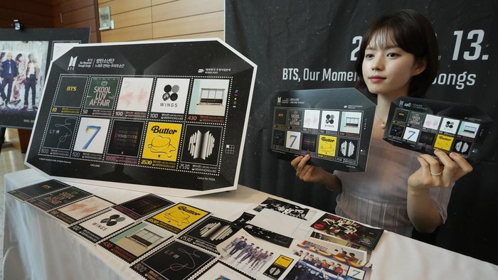 A model shows sheets of postage stamps marking the 10th debut anniversary of K-pop band BTS at a post office in Seoul, South Korea, Monday, June 12, 2023. Post offices start selling the stamps Tuesday. (AP Photo/Ahn Young-joon)
