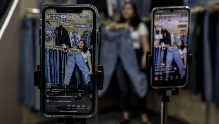 Pedagang menawarkan pakaian secara daring melalui siaran langsung di Pasar Tanah Abang, Jakarta, Selasa (13/6/2023). Menurut pedagang setempat 40-50 persen dari total omzet penjualan yang berkisar Rp50 juta per bulan itu berasal dari penjualan secara daring melalui siaran langsung di media sosial dan marketplace. ANTARA FOTO/Aprillio Akbar/aww.