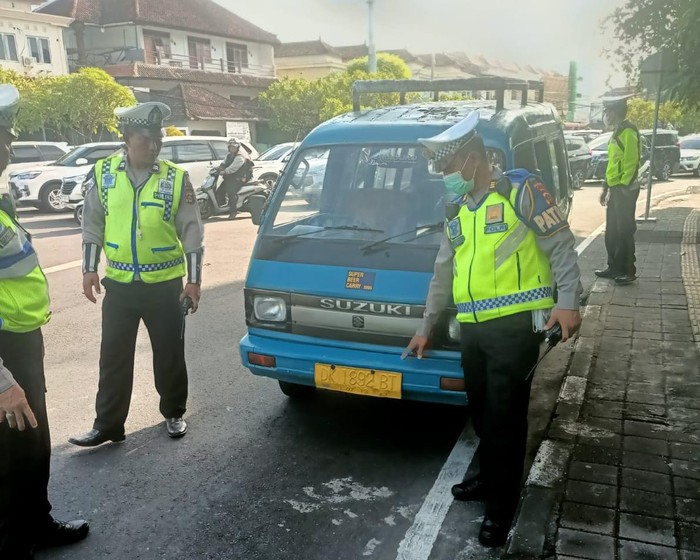 Viral sopir bule berkebangsaan AS mengendarai angkot. Polisi telah menilang WNA itu dan menyita mobil biru sebagai barang bukti.