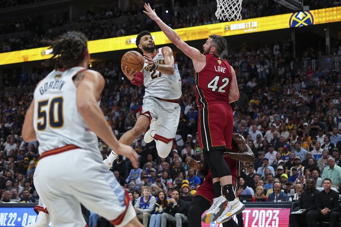 Denver Nuggets guard Jamal Murray, center, shoots while defended by Miami Heat forward Kevin Love, right, during the second half of Game 5 of basketballs NBA Finals, Monday, June 12, 2023, in Denver. (AP Photo/Jack Dempsey)