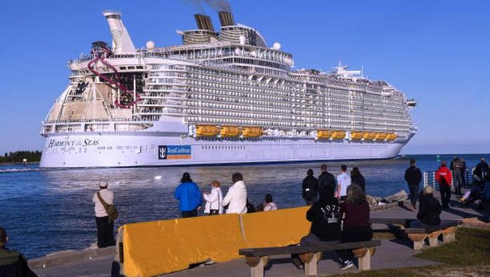 PORT CANAVERAL, FLORIDA, UNITED STATES - 2022/01/30: People watch as the Royal Caribbean Harmony of the Seas cruise ship departs from Port Canaveral, about an hour before the scheduled launch from nearby Cape Canaveral Space Force Station of a SpaceX Falcon 9 rocket carrying a radar surveillance satellite for the Italian space agency. 
The launch was scrubbed at the last minute when an unnamed cruise ship entered the designated launch hazard area. (Photo by Paul Hennessy/SOPA Images/LightRocket via Getty Images)