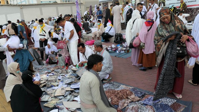 Jamaah Haji Indonesia Serbu Pasar Oleh-oleh Dadakan di Mekkah Jamaah calon haji memilih makanan yang dijual di sekitar hotel kawasan Syisyah, Mekah, Arab Saudi, Senin (12/6/2023). Penjual dadakan mulai membanjiri kawasan hotel tempat jamaah Indonesia menginap dengan menjual pakaian dan suvenir untuk oleh - oleh keluarga di tanah air. ANTARA FOTO/Wahyu Putro A/nym.