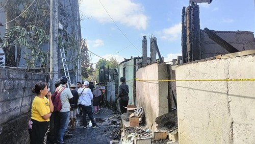 Daeng Siti (baju kuning) nampak menatap rumahnya yang habis terbakar, Selasa (13/6/2023).