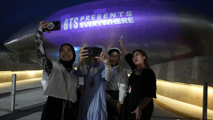 Landmark Korsel Diterangi Warna Ungu Saat Hari Jadi BTS Ke-10 The landmark Dongdaemun Design Plaza is illuminated in purple as fans take a selfie in Seoul, South Korea, Monday, June 12, 2023. Skyscrapers, bridges and other landmarks in South Korea's capital will be lit up in purple on Monday as the country begins celebrating the 10th anniversary of K-pop band BTS, whose global popularity is a source of national pride. (AP Photo/Ahn Young-joon)