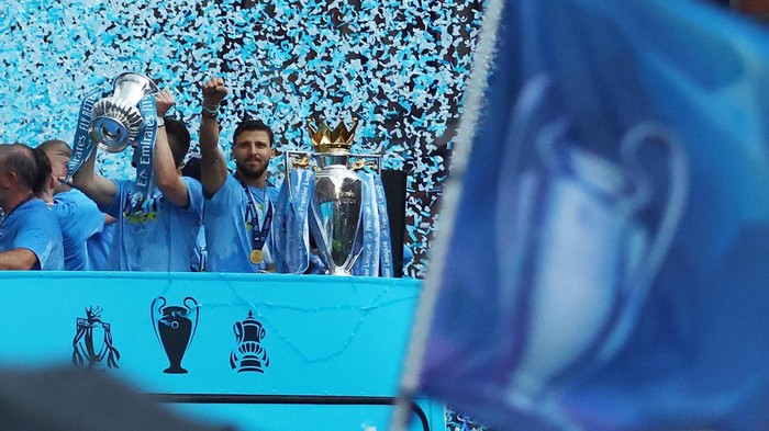 Soccer Football - Manchester City Victory Parade - Manchester, Britain - June 12, 2023
Manchester Citys Phil Foden celebrates with the Champions League trophy as Aymeric Laporte celebrates with the FA Cup trophy and Ruben Dias celebrates with the Premier League trophy during the parade REUTERS/Molly Darlington