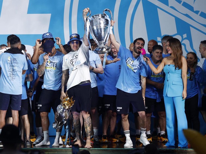 Soccer Football - Manchester City Victory Parade - Manchester, Britain - June 12, 2023
Manchester City's Phil Foden celebrates with the Champions League trophy as Aymeric Laporte celebrates with the FA Cup trophy and Ruben Dias celebrates with the Premier League trophy during the parade REUTERS/Molly Darlington