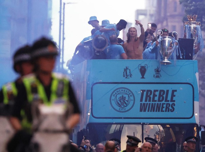 Soccer Football - Manchester City Victory Parade - Manchester, Britain - June 12, 2023
Manchester City's Phil Foden celebrates with the Champions League trophy as Aymeric Laporte celebrates with the FA Cup trophy and Ruben Dias celebrates with the Premier League trophy during the parade REUTERS/Molly Darlington