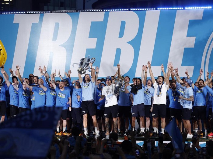 Soccer Football - Manchester City Victory Parade - Manchester, Britain - June 12, 2023
Manchester City's Phil Foden celebrates with the Champions League trophy as Aymeric Laporte celebrates with the FA Cup trophy and Ruben Dias celebrates with the Premier League trophy during the parade REUTERS/Molly Darlington