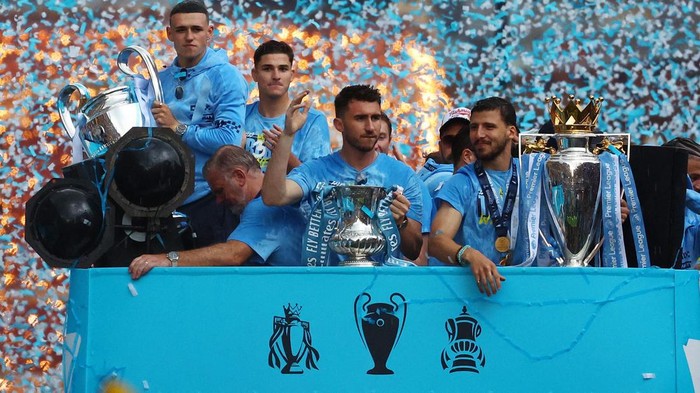 Soccer Football - Manchester City Victory Parade - Manchester, Britain - June 12, 2023
Manchester Citys Phil Foden celebrates with the Champions League trophy as Aymeric Laporte celebrates with the FA Cup trophy and Ruben Dias celebrates with the Premier League trophy during the parade REUTERS/Molly Darlington