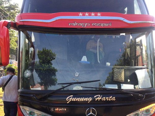 Bus pariwisata Gunung Harta yang kacanya dilempar pakai batu oleh tiga pria di Jembrana, Bali, Selasa (13/6/2023).