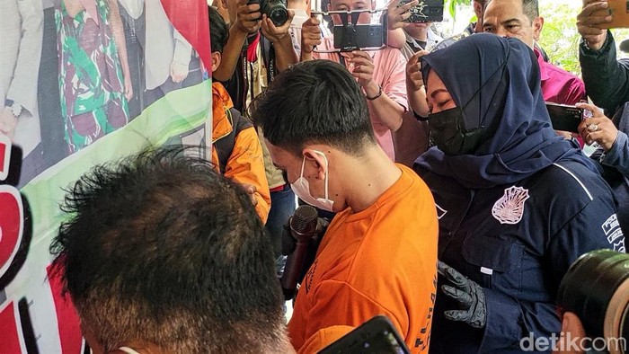 RA menundukan kepala saat menjawab pertanyaan pertugas terkait keterlibatannya dalam pemalsuan identitas