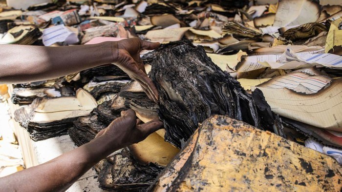 Archival and documentation students sift through burned documents at the Cheikh Anta Diop University in Dakar on June 09, 2023 in an effort to salvage them. Tens of thousands of student archives dating back to 1957 where burned during protest that broke out on June 01, 2023 after opposition leader Ousmane Sonko was sentenced to two years in prison. (Photo by JOHN WESSELS / AFP) (Photo by JOHN WESSELS/AFP via Getty Images)